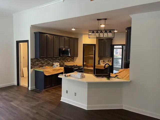 Kitchen with dark cabinets, island and tile backsplash