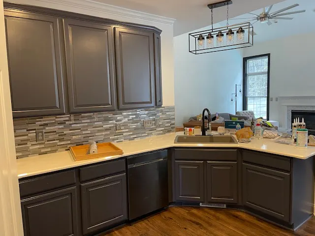 L-shaped kitchen with dark cabinets and quartz counters