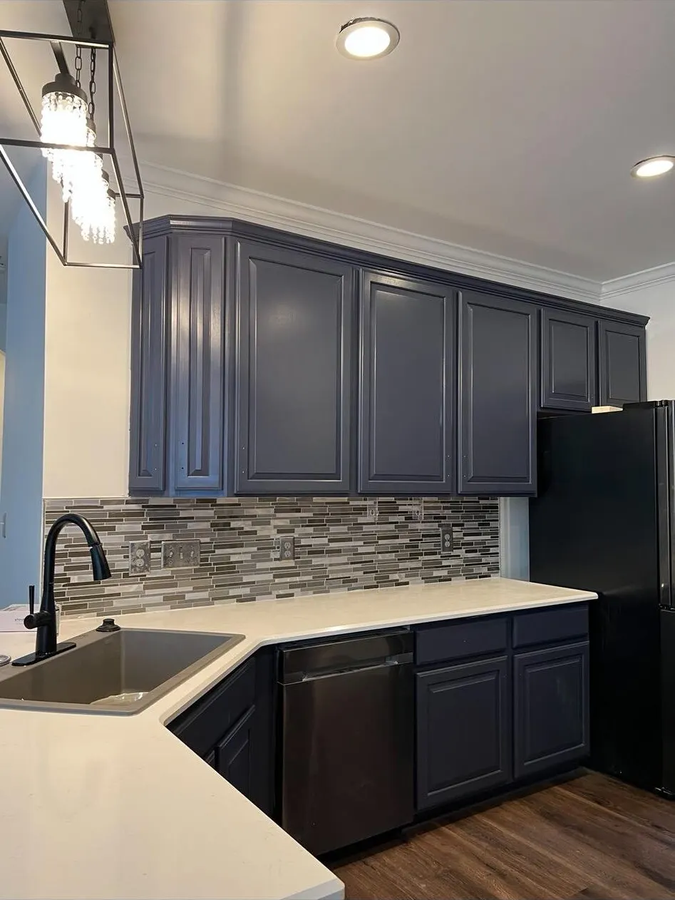 Kitchen with navy cabinets and mosaic backsplash