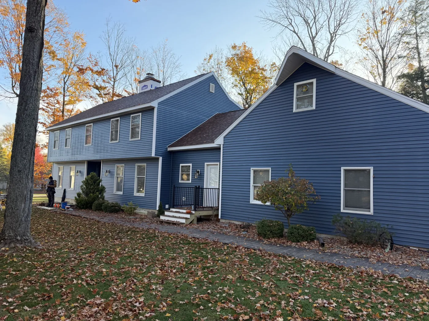 Colonial home with new blue vinyl siding and roof